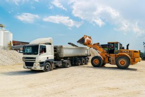 a front end loader loading sand to a truck